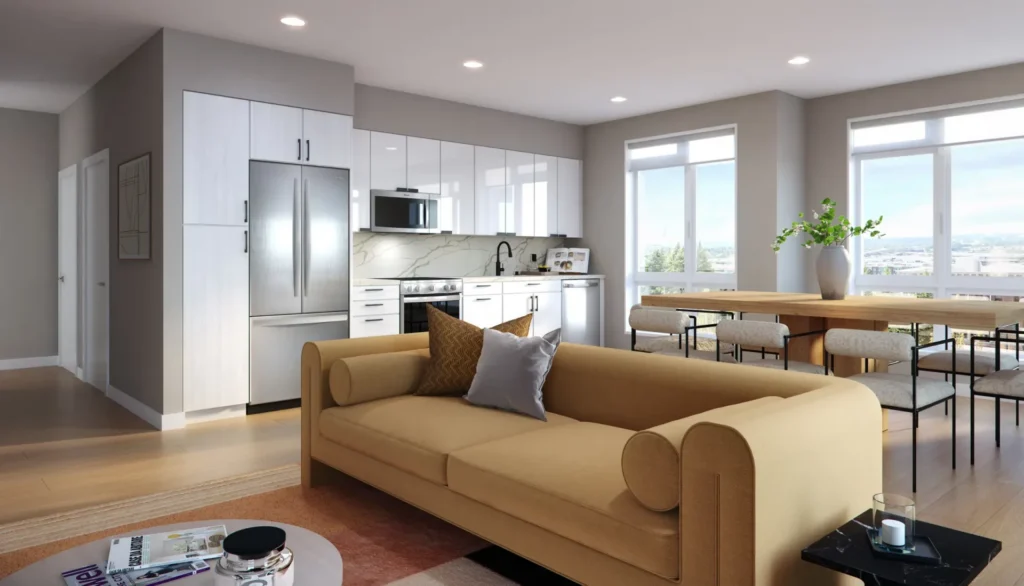 Modern apartment with an open-plan kitchen and living area. Cozy tan sofa faces a stylish kitchen with stainless steel appliances. Large windows let in natural light over a dining table with chairs and a plant.